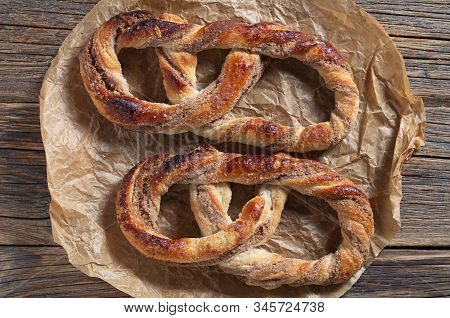 Two Sweet Pretzels On Crumpled Paper Located On An Old Wooden Background Close-up, Top View
