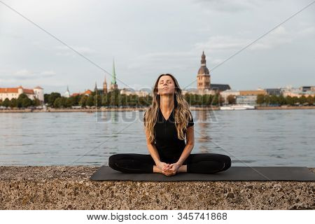 Yoga Meditation And Wellness Lifestyle Concept. Fit Slim Woman Practicing Yoga Exercises Near River 