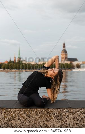 Yoga Meditation And Wellness Lifestyle Concept. Fit Slim Woman Practicing Yoga Exercises Near River 