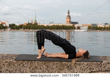 Yoga Meditation And Wellness Lifestyle Concept. Fit Slim Woman Practicing Yoga Exercises Near River 