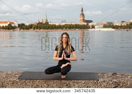 Yoga Meditation And Wellness Lifestyle Concept. Fit Slim Woman Practicing Yoga Exercises Near River 