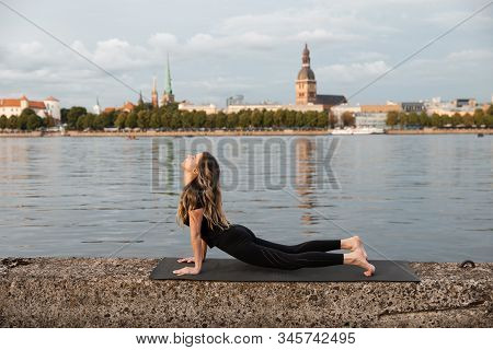 Yoga Meditation And Wellness Lifestyle Concept. Fit Slim Woman Practicing Yoga Exercises Near River 