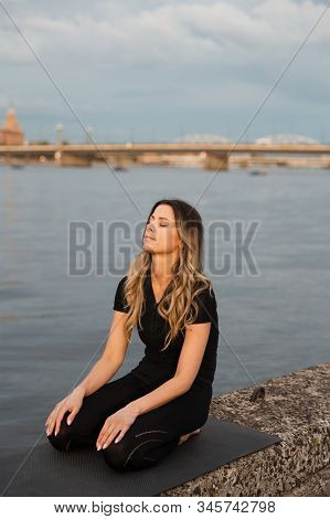 Yoga Meditation And Wellness Lifestyle Concept. Fit Slim Woman Practicing Yoga Exercises Near River 
