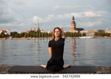 Yoga Meditation And Wellness Lifestyle Concept. Fit Slim Woman Practicing Yoga Exercises Near River 
