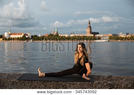 Yoga Meditation And Wellness Lifestyle Concept. Fit Slim Woman Practicing Yoga Exercises Near River 