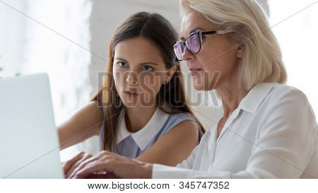 Aged Apprentice Young Mentor Working Together Seated At Workplace Desk