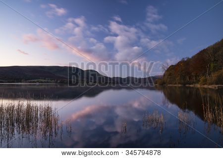 Epic Vibrant Sunrise Autumn Fall Landscape Image Of Ullswater In Lake District With Golden Sunlight