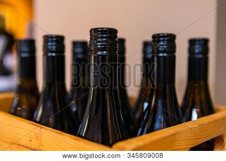 Wines Bottle Dark Amber Glass Top, Finish And Neck Close Up, Selective Focus View Of Bottles On Wood