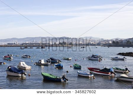 Boats In O Cocho Beach In Alcabre Neighborhood. Bouzas And Vigo City On Background.