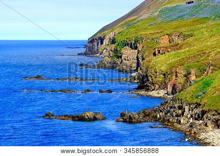 Spectacular View Of The Cliffs And Rock Formation By The Ocean In The Summer Near Olafsfjordur, Icel