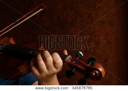 Child Hands Holding Violin And Playing Symphony. Kid Violinist Playing Music Concept