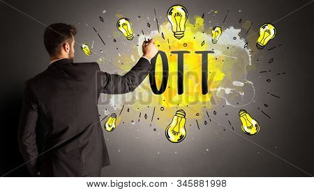 businessman drawing colorful light bulb with OTT abbreviation, new technology idea concept