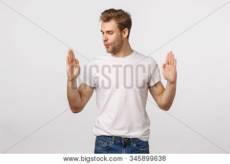 Handsome Blond Young Man Amazed With Size Of Product As If Holding Something Large Or Big, Shaping O