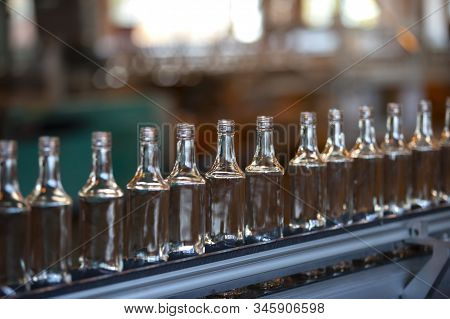 Glassworks. Glass Industry. Many Glass Bottles On A Factory Conveyor.