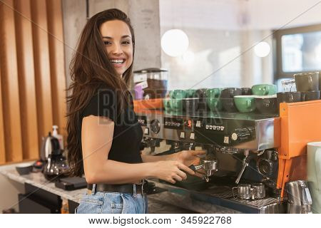 Smiling Barista Woman Preparing Coffee For Client Standing With Coffee Holder Full Of Coffee Beans N