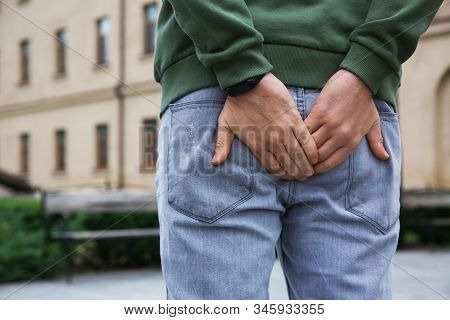 Man Suffering From Hemorrhoid Pain Outdoors, Back View