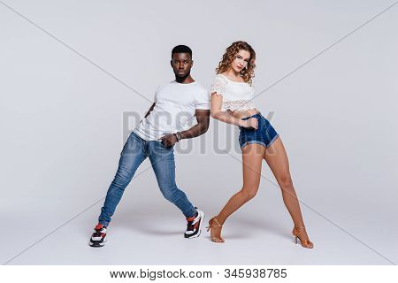 Couple Dancers Posing Over White Background. Man And Woman Are Dancing, Dance Costumes. Internationa