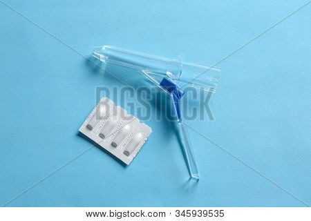 Anoscope And Suppositories On Light Blue Background, Flat Lay. Hemorrhoid Treatment