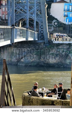 Oporto, Portugal- December 30, 2020: People Enjoying Drinks In A Bar Terrace On The Banks Of The Dou