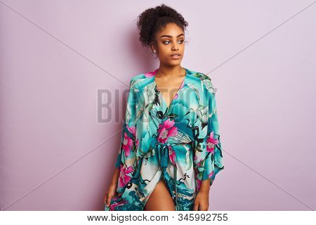 Young beautiful african american woman standing wearing elegant colorful caftan