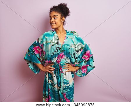 Young beautiful african american woman standing wearing elegant colorful caftan