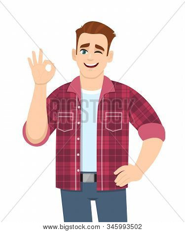 Trendy Young Man Showing Okay Sign And Winking Eye. Stylish Person Making Ok Or Cool Gesture With Fi