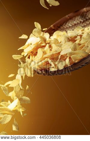 Falling Potato Chips On A Yellow Background. Copy Space.