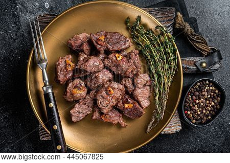 Chopped Grilled Diced Beef Garlic Steak On A Plate With Thyme. Black Background. Top View