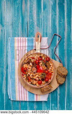 Braised Beans With Vegetables And Fried Sausages On A Wooden Background. Top View.