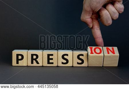 Pression To Free Press Symbol. Businessman Turns Wooden Cubes And Changes The Word Pression To Press