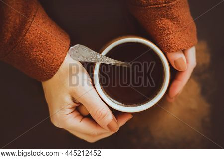 A Woman With A Brown Manicure And A Brown Woolen Jacket Is Holding A Beige Mug With Hot Fragrant Cof