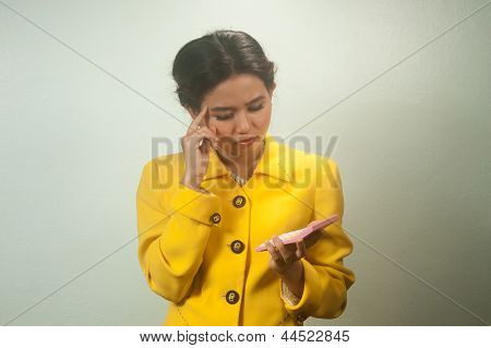 Muito jovem mulher asiática no fato amarelo uso calculadora.