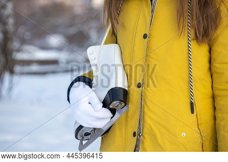 Close Up Of Female Hands Holding Ice Skates.
