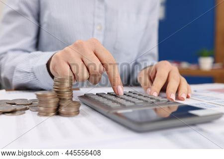 Close-up Of Female Count On Silver Calculator, Cash Coins On Office Desk. Calculation Of Income, Tax