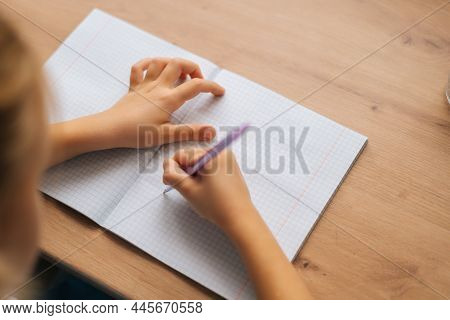 Close-up Cropped Shot Of Unrecognizable Elementary Little Child Girl Writing Doing Homework Sitting 