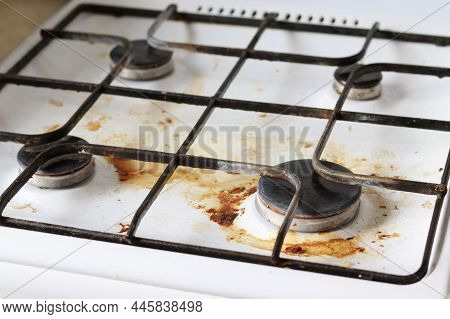 Dirty Gas Stove With Food Debris And Grease Stains. A Dirty Gas Stove With Grease Stains, Old Grease