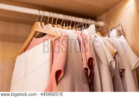 Hangers With Different Clothes In Wardrobe Closet.shirts And Dress Hanging On Rail In Wooden Wardrob