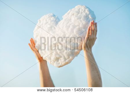Young man get the heart - cloud to make proffer to his girlfriend from blue clear sky