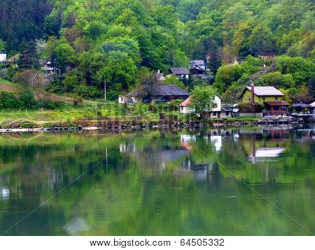 Buildings and trees reflected in water