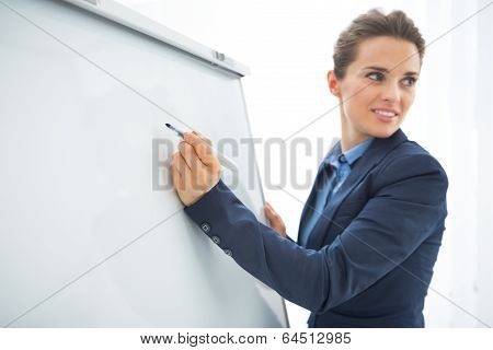 Closeup On Business Woman Writing In Flipchart