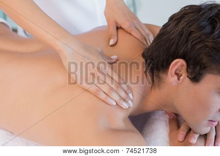 Close up mid section of a man receiving back massage at spa center