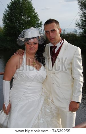 Young bride and groom couple posing outside