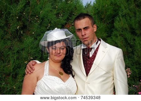Young bride and groom couple posing outside