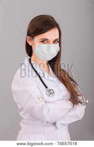 Doctor / Nurse Smiling Behind Surgeon Mask. Closeup Portrait Of Young  Caucasian Woman Model In Whit
