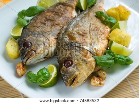Baked gilt-head garnished with basil and green lime slices