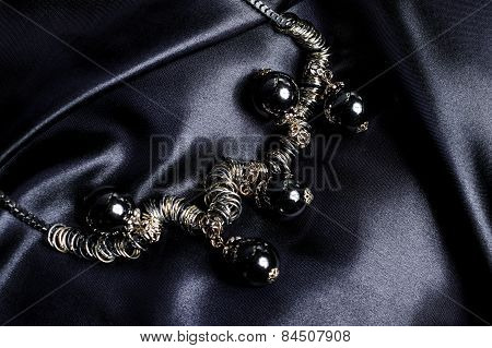 Necklace With Black Beads On Silk Background