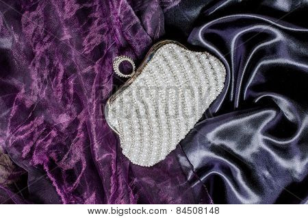 Clutch With Pearls On A Silk Background