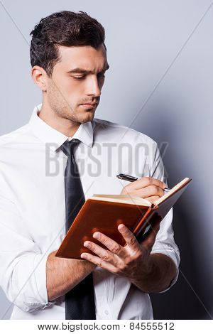 человек записывает в блокнот глядя на экран