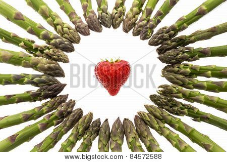 Circle Of Asparagus Tips Pointing At Strawberry.