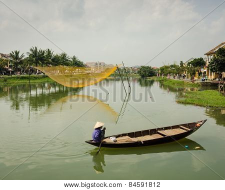 Vietnamese woman paddles a traditional boat on the Thu Bòn River